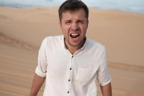 Angry man shouting accusing someone standing in desert Stock Photos