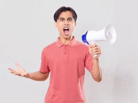 Angry man shouting into a megaphone looking at the camera isolated on white.. Stock Photos