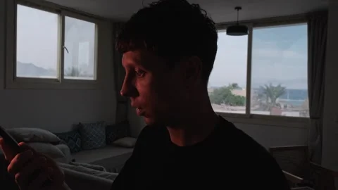 Angry man shouting no into his phone during a heated conversation at home, then Видео 347299870