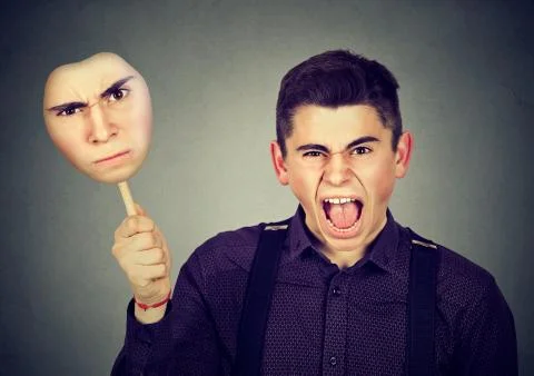 Angry man taking off mask with grumpy face expression 스톡 사진