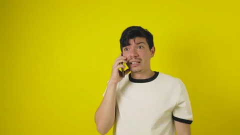 Angry man talking on smartphone on isolated yellow background Stock Footage 311945553