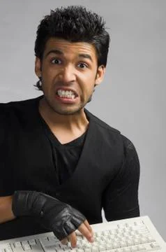 Angry man typing on a computer keyboard 写真素材