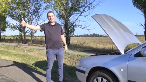 An angry man votes on the road. The driver stands near his car with the hood ope Stock Footage 138138435