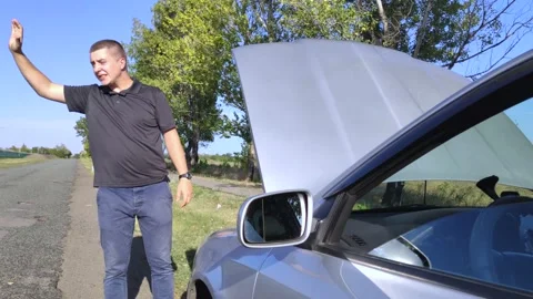 An angry man votes on the road. The driver stands near his car with the hood ope Stock Footage 138138519