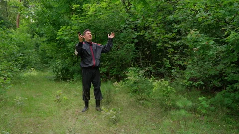 Angry man walking looking at smartphone lost in forest Stock Footage 158142543