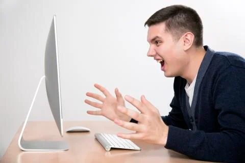 Angry man yelling on computer screen Stock Photos