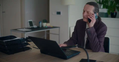 Angry manager working on laptop using smartphone in office Stock Footage 268446959