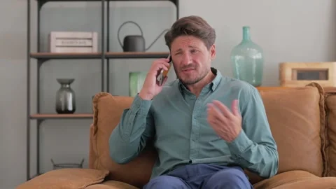Angry Middle Aged Man Talking on Phone at Home Stock Footage 287418797
