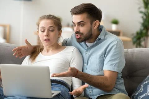 Angry millennial couple having computer problems at home 库存照片