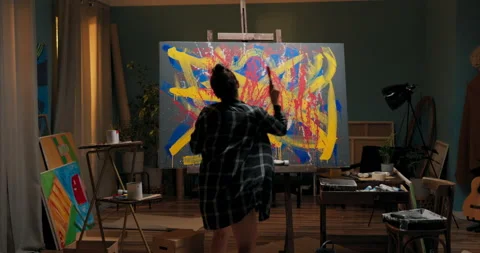 Angry painter spends evening in artist's studio in hand she holds container of Stock Footage 161776495