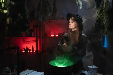 Angry represented realistic witch brewing a potion in cauldron crossed arms.. Stock Photos