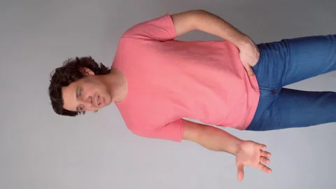 Angry sad curly man makes a claim posing in studio on gray background. Stock Footage 311874222