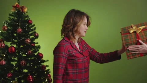 Angry scared girl refusing a gift fighting on green background. Fun scene Stock Footage 165405171