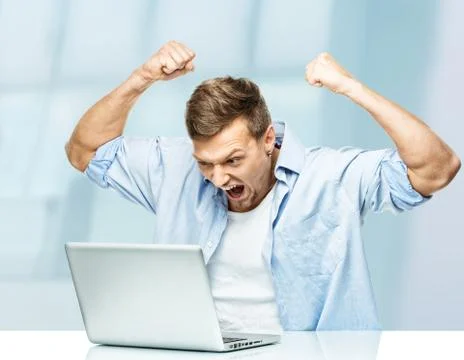 Angry stylish young man behind laptop Stock Photos