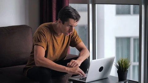 Angry Troubled Stressed Man Having Problem While Using Laptop, While Sitting on Video stock 125036973