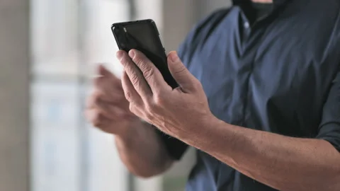 Angry upset man hitting mobile phone that doesn't work Stock Footage 221759277