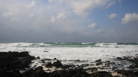 Angry waves breaking on the black rocks in the ocean of Jeju island Video stock 58470337