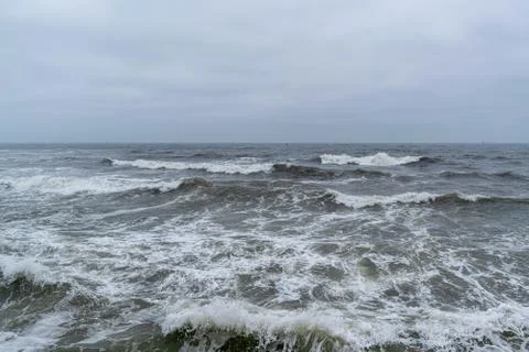 Angry waves in the ocean with strong currents and a moody sky. Beach and sea Stock Photos