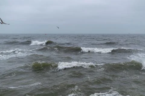 Angry waves in the ocean with strong currents and a moody sky. Beach and sea Stock Photos