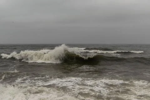 Angry waves in the ocean with strong currents and a moody sky. Beach and sea Stock Photos