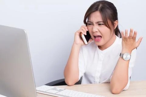 Angry woman use the smartphone at the office Stock Photos