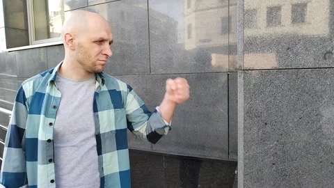 Angry young man hits wall of building with his fist Video stock 201636036