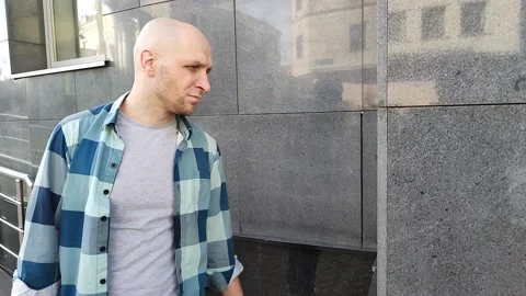 Angry young man hits the wall of building with his fist Stockbeeldmateriaal 201891902