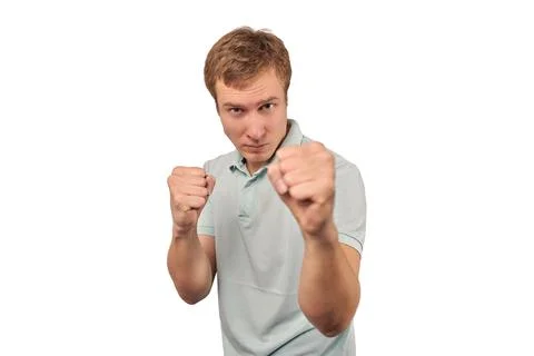 Angry young man in mint T-shirt ready to fight with fists isolated on white b Stock Photos