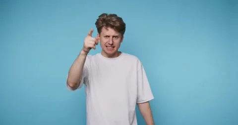 Angry young man pointing his finger with a stern expression, manifesting fr.. Stock Footage 313280962