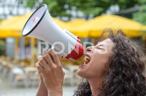 Angry young woman using a loud hailer Stock Photos