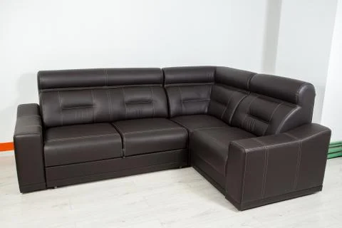 Angular black leather sofa on a neutral background Stock Photos