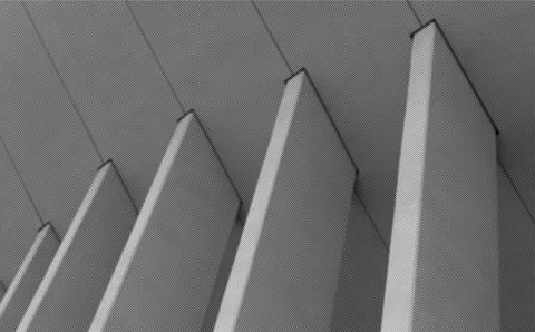 Angular concrete fins rise from facade creating sharp sculptural architectura Stock Photos