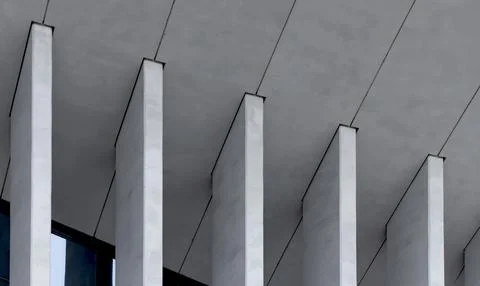 Angular concrete supports extend from ceiling creating rhythmic structural Stock Photos