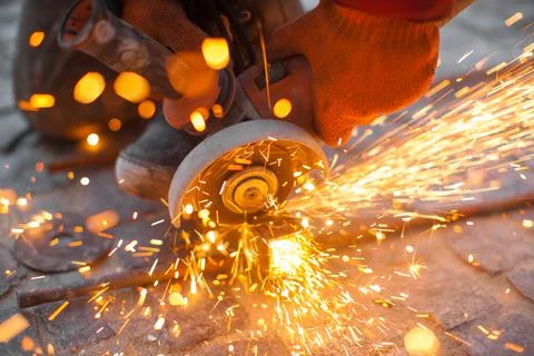 Angular grinding machine cuts metal with sparks Stock Photos