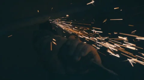The angular grinding machine is cutting the pipe and flying a lot of sparks  Stock Footage 64878126
