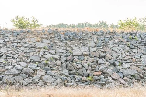 Angular, irregularly shaped gray stones in a rugged stacked pattern forming.. Photos