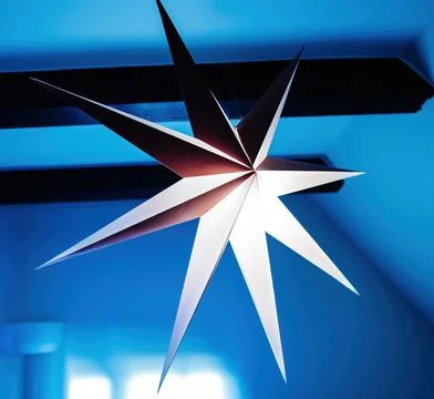Angular Paper Star Lamp Against Blue Background Stock Photos