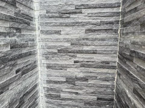 Angular shot displays an exterior brick wall's distinctive gray hues and ston Foto stock
