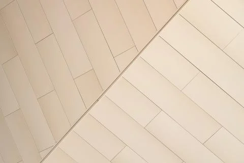 Angular view of beige color tiled wall of refracted relief Foto stock
