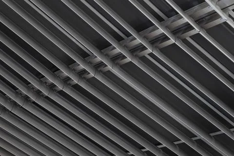Angular view close-up of dark metal beams structure in ceiling of building Fotos de archivo