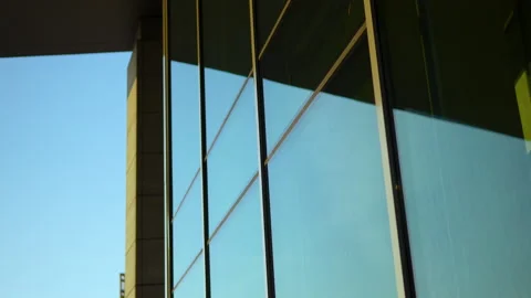 Angular view of a glass facade with metal framing, capturing sky Vídeos de archivo 254547572