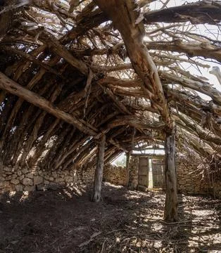 Angular view of the interior of an old livestock shelter, with a collapsed Stock Photos