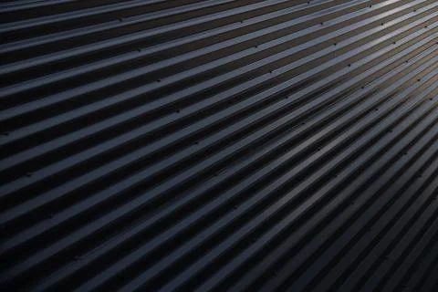 Angular view of metal shiny black corrugated surface Foto stock