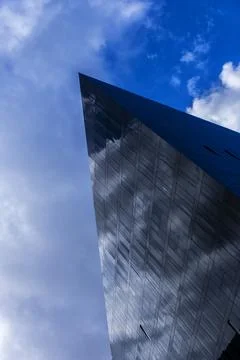 Angular view of modern glass building with blue sky Stock-Fotos