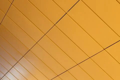 Angular view of warm yellow color tiled wall with perspective Stock Photos