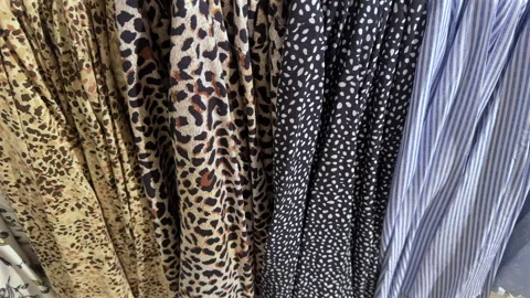Animal Print and Patterned Skirts Hanging on Clothing Rack in Store Stock Footage 347486133