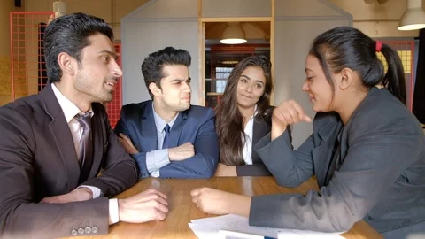 Animated discussion between Indian colleagues in an informal setting as their co Stock Footage 104539089