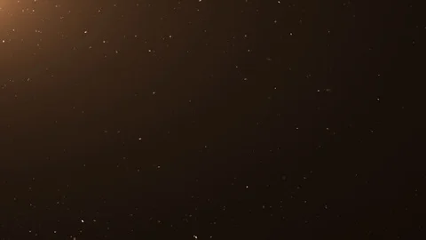 Animated dust particle background over a dark background with warm lens flare. Stock Footage 107669623
