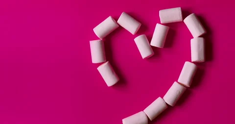 Animated heart-shaped marshmallows. A sweet snack on Valentine's Day. Stock Footage 147023132