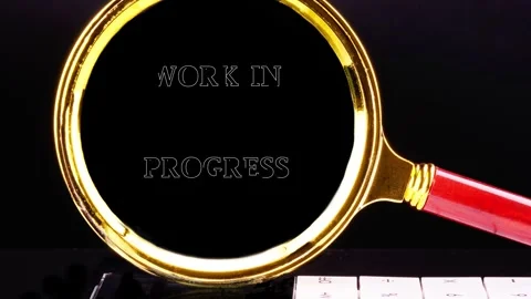 Animated WORK IN PROGRESS text, viewed through a magnifying glass with a gold Stock Footage 332055572